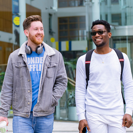 Two NCI students walking outside NCI Mayor Square campus building